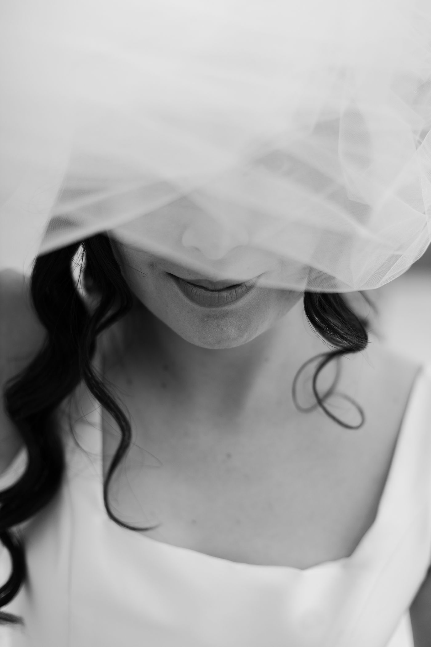 Black and white portrait of a bride beneath her veil